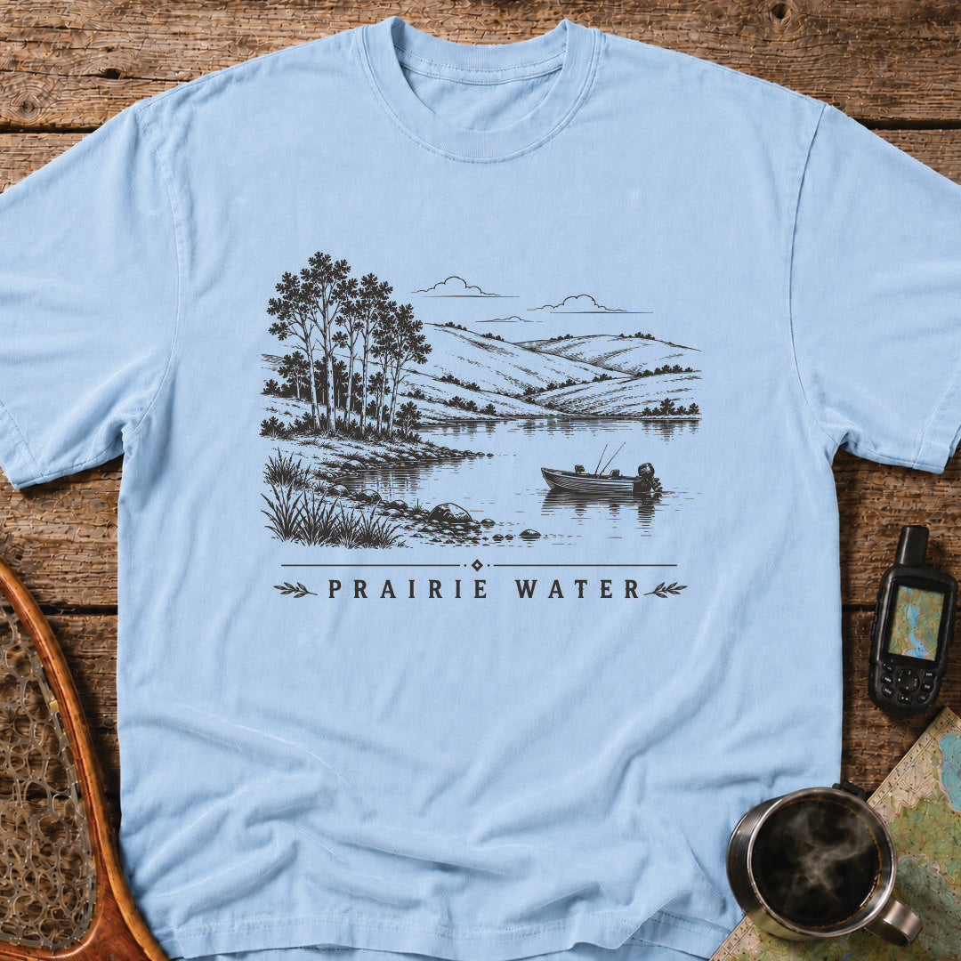 Small fishing boat drifting on a quiet prairie lake surrounded by rolling hills.