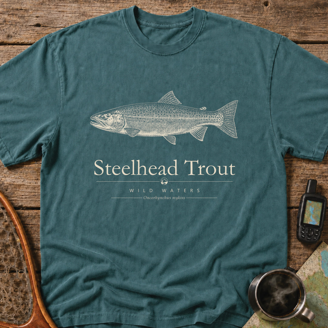 Blue Spruce Comfort Colors T-shirt featuring a vintage cream steelhead trout illustration, Wild Waters typography, and the scientific name Oncorhynchus mykiss.