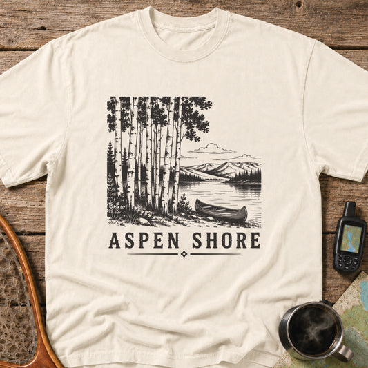 Vintage canoe resting beside a wilderness lake surrounded by aspen trees and mountain scenery.