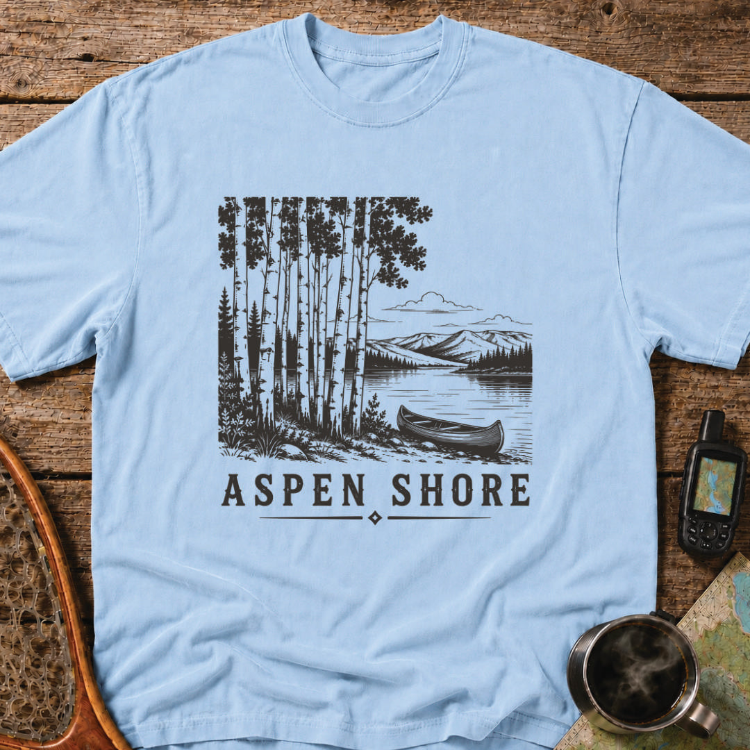 Vintage canoe resting beside a wilderness lake surrounded by aspen trees and mountain scenery.