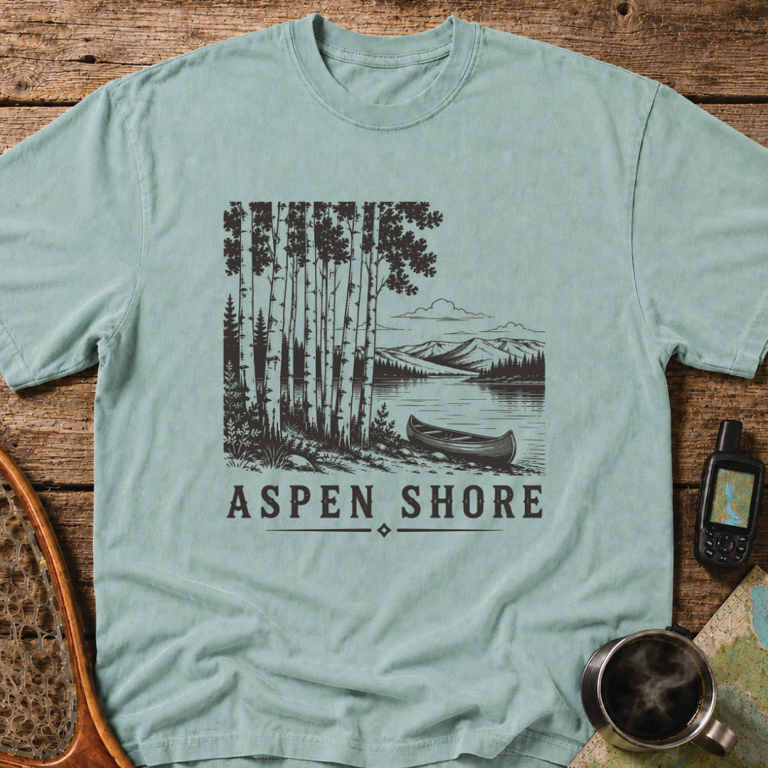 Vintage canoe resting beside a wilderness lake surrounded by aspen trees and mountain scenery.