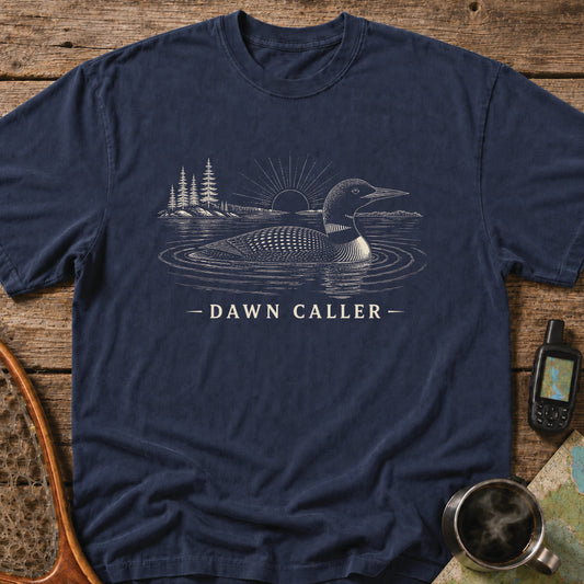 Dawn Caller loon t-shirt featuring a detailed loon floating on a northern lake at sunrise with wilderness shoreline artwork.