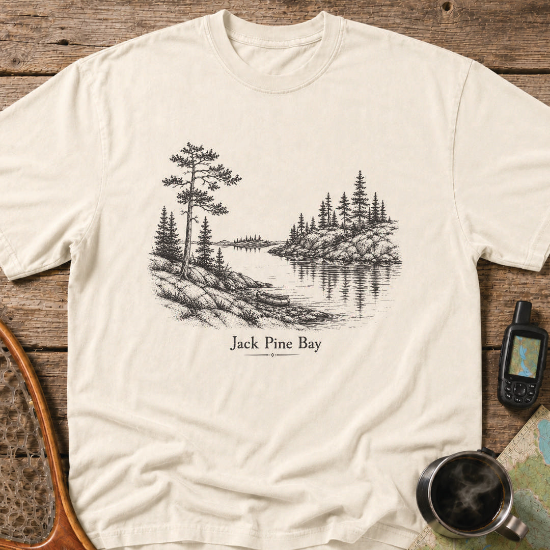 Jack Pine Bay t-shirt featuring a granite shoreline with jack pine overlooking calm water.