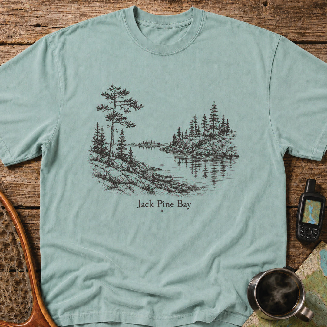 Jack Pine Bay t-shirt featuring a granite shoreline with jack pine overlooking calm water.