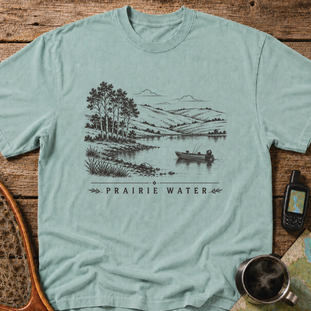 Small fishing boat drifting on a quiet prairie lake surrounded by rolling hills.