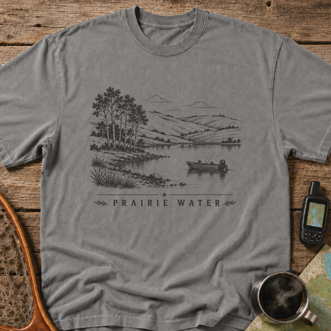 Small fishing boat drifting on a quiet prairie lake surrounded by rolling hills.