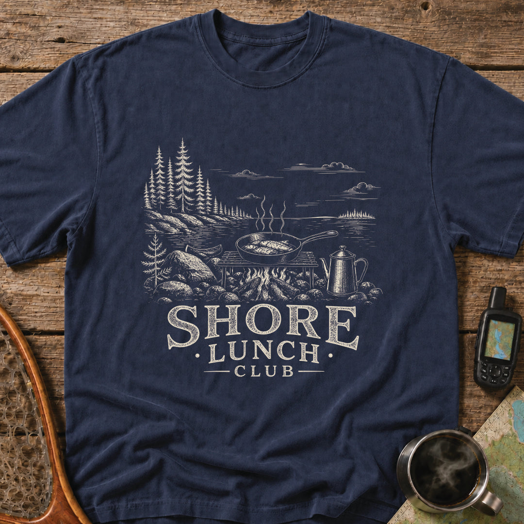 Granite Shore t-shirt featuring a rocky northern shoreline with pine trees overlooking calm wilderness water.