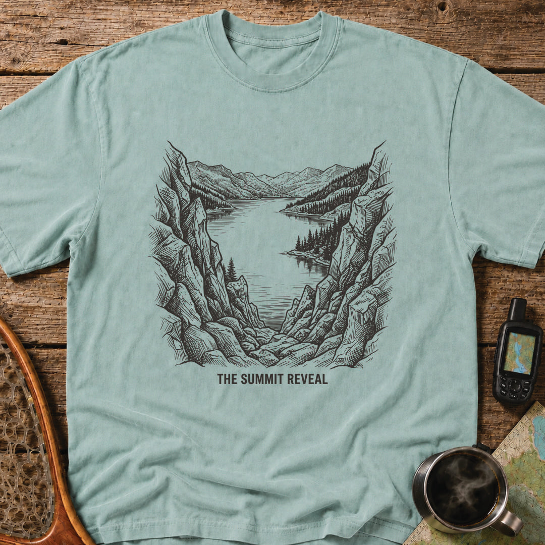 The Summit Reveal t-shirt featuring a dramatic mountain overlook above an alpine lake.